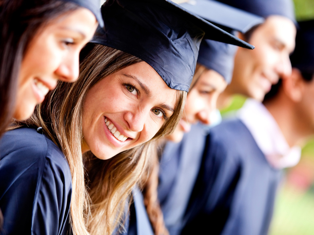 File details Woman standing out from a graduation group smiling